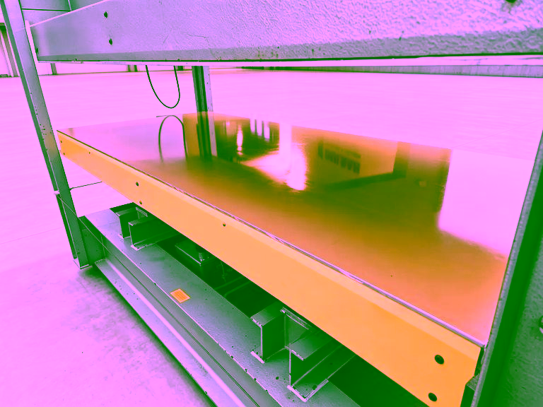 Lower heated platen of the press, seen from the side