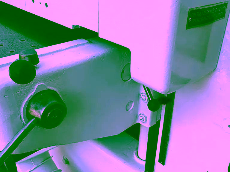 Thickness scale and adjustment levers beside the infeed table