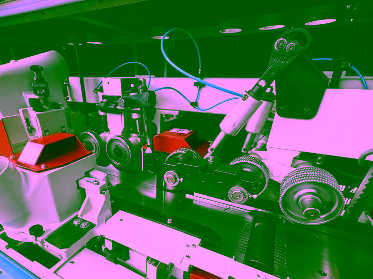 Feed and pressure rollers between the spindles